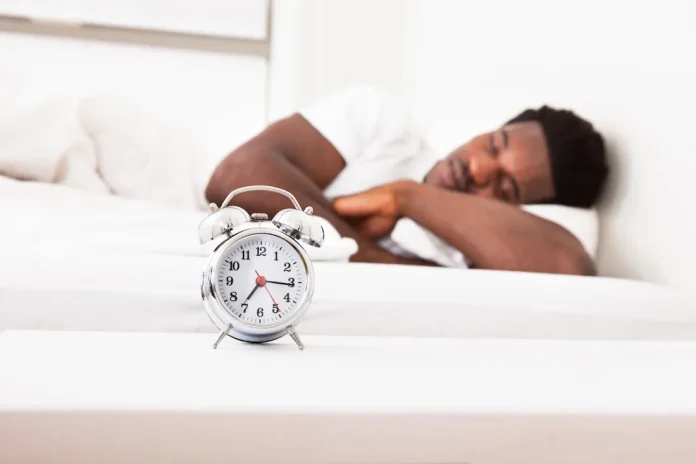 Man-sleeping-near-alarm-clock